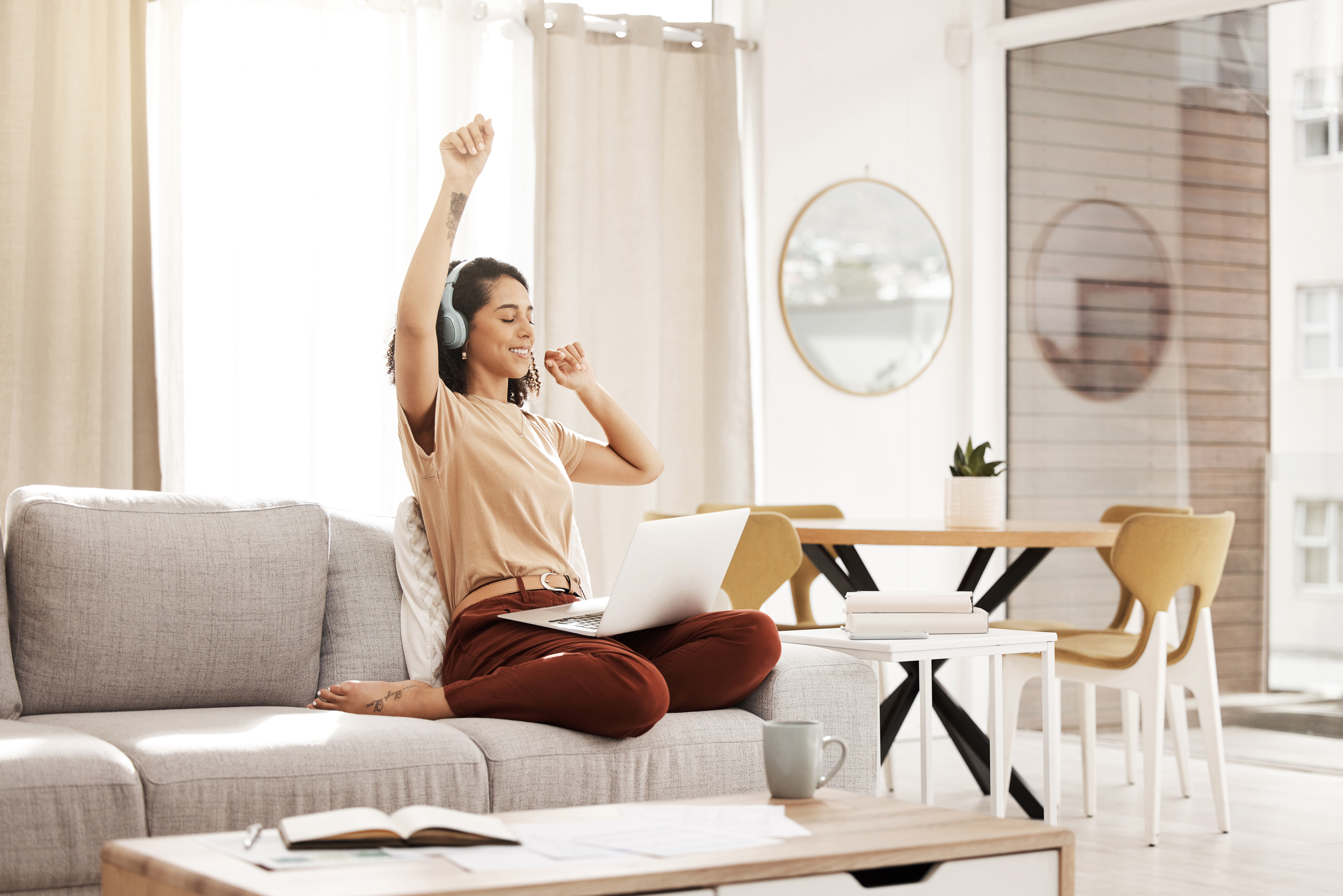 Music, laptop and woman dance on sofa while streaming audio podcast, radio sound or digital online