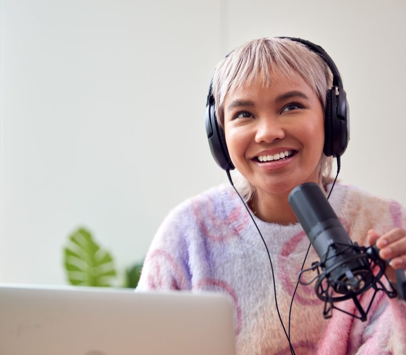 Woman Recording Podcast Or Broadcasting On Radio In Studio At Home With Laptop
